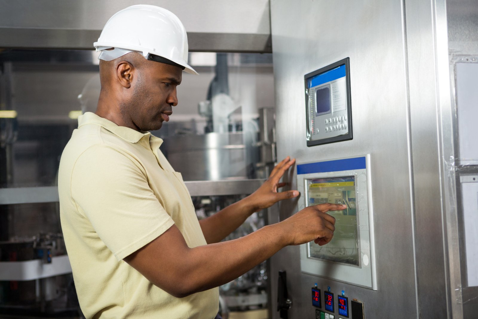 Confident male employee operating machine in manufacturing industry